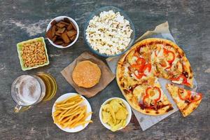 Fast food on old wooden background. Concept of junk eating. Top view. photo