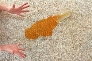 Glass of juice fell on carpet. Drink spilled on floor. photo