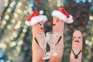 Fingers art of happy couple laughing in New Year hats. Child is angry and resentful. Fingers art of couple celebrates Christmas. photo