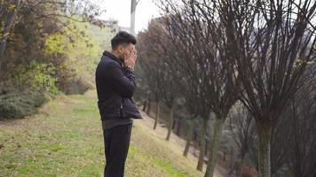 The man standing outside in the city. Frustration. The disappointed young man stands outdoors and looks at the sky. video