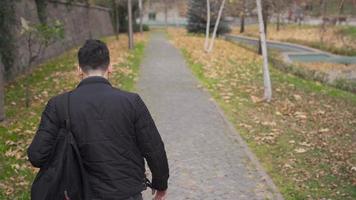 el hombre caminando al aire libre siente triste. salir. el solitario hombre camina en el ciudad centro. infelicidad y arrepentirse. video