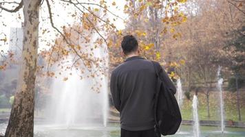 jung männlich Schüler ist Tanzen im das Park und ist glücklich. Gefühl gut männlich Schüler mit Rucksack auf seine zurück Tanzen und haben Spaß. video