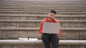 He studies alone in the amphitheater of the university student school. Young man studying at university is sitting alone in his school's amphitheater and studying. video