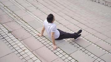 Young man alone on the street looks around. Unhappy with loneliness, the young man looks around thoughtfully. video