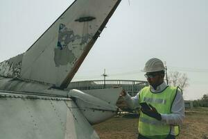 Aircraft mechanic examining airplane wing photo