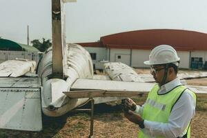 Aircraft mechanic examining airplane wing photo