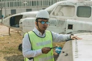 Aircraft mechanic examining airplane wing photo