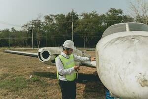 Aircraft mechanic examining airplane wing photo