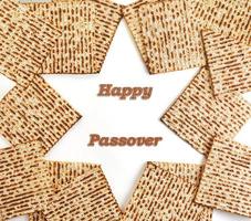 Pesach celebration concept - Jewish holiday Pesach. Folded matzah in the shape of star of david isolated on white background. Copy space for text. Flat lay. photo