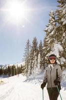 joven mujer disfrutando invierno día de esquiar divertido en el nieve foto