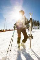 joven mujer disfrutando invierno día de esquiar divertido en el nieve foto