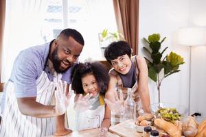 Happy African American family enjoy together while prepare the flour for making cookies at home photo