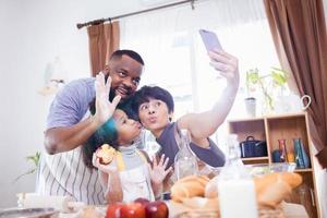 Happy African American family enjoy together while prepare the flour for making cookies at home photo