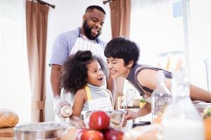 Happy African American family enjoy together while prepare the flour for making cookies at home photo