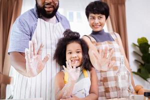 Happy African American family enjoy together while prepare the flour for making cookies at home photo