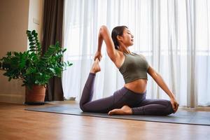 experiencia el beneficios de yoga con un asiático mujer guiado práctica a hogar foto