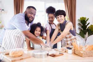 Happy African American family enjoy together while prepare the flour for making cookies at home photo