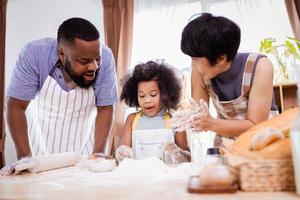 Happy African American family enjoy together while prepare the flour for making cookies at home photo