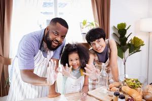 Happy African American family enjoy together while prepare the flour for making cookies at home photo