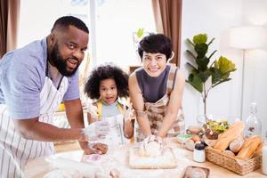 Happy African American family enjoy together while prepare the flour for making cookies at home photo