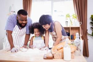 Happy African American family enjoy together while prepare the flour for making cookies at home photo