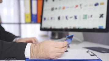 Male man making purchase with credit card in online store. Male hands holding credit card making contactless, online payment on online shopping website. video