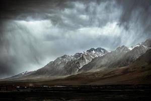 The towering snow-capped mountains are about to be covered by storm photo