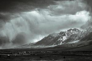 The towering snow-capped mountains are about to be covered by storm photo