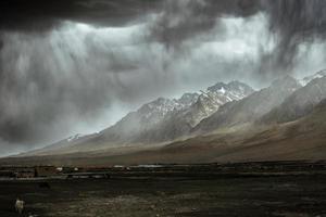 The towering snow-capped mountains are about to be covered by storm photo