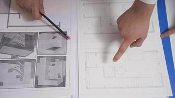 Male architect completes interior design drawings of a shop in his night office. Male designer working in modern office finishing drawing of a new project. Interior architectural drawings. video