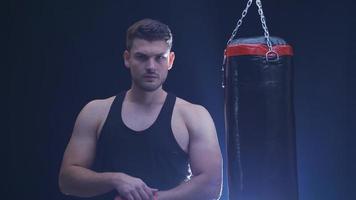 Focused ambitious boxer man. Young boxer wrapping bandage on his hand and looking at camera, focused and serious boxer. video