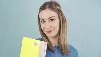 Young student woman holding books and looking at camera. Happy and excited schoolgirl smiling at camera. video