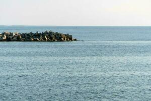 Minimalism seascape. Breathtaking view of sea with breakwaters. Traveling dreams, copy space. Clean blue sea water. photo