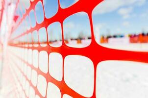 Safety outdoor slope track fence, winter background. Fence to protect spectators at sports events, or to indicate course at extreme sports - dog sledding, snowboarding or skiing photo