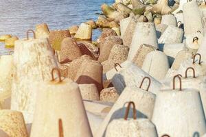 Breakwaters in sea. Beautiful sunset seascape with concrete tetrapodes for protect coastal structures from storm sea waves, effects of longshore drift and weather photo