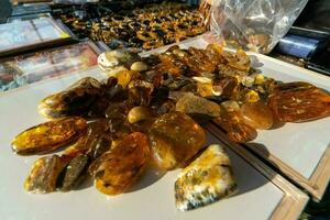 Amber stones on counter of street vendor. Real, not fake raw baltic amber stones for making jewelry and jewelery. photo