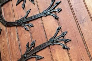 Forged pattern on door with decorative elements. Old vintage entrance, massive heavy wooden door of church or cathedral. photo