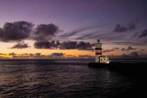 puesta de sol a el gardur antiguo faro en Islandia foto