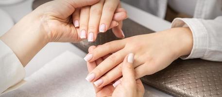 Manicurist showing manicure on fingers photo
