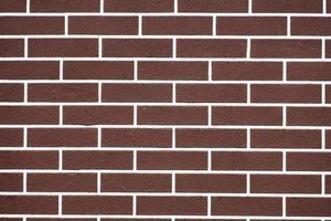 pared de ladrillo marrón con patrón de líneas de lechada blanca foto