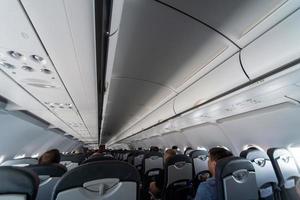 Airplane cabin seats with passengers. Economy class of new cheapest low-cost airlines without delay or cancellation of flight. Travel trip to another country. photo