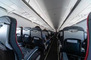 asientos de cabina de avión con pasajeros. clase económica de las nuevas aerolíneas de bajo costo más baratas. viaje viaje a otro país. turbulencia en vuelo. foto