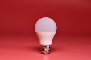 Light bulb, copy space. Energy saving minimal idea concept.Pink background. photo