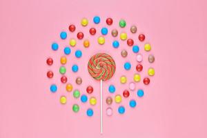 Sweet lollipop and candy on pink background