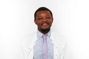 Happy black doctor man with small beard in white coat bright shirt isolated on white background photo