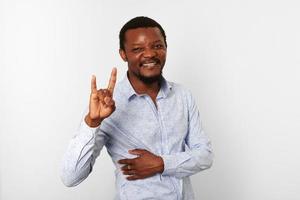 Happy african american black man with sign of horns gesture in casual bright shirt, white background photo