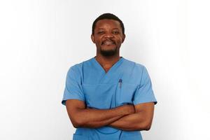 Smiling black surgeon doctor bearded man in blue coat with crossed arms isolated on white background photo