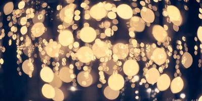 Pale yellow lights bokeh from christmas holiday garlands, blurred festive abstract background lights photo