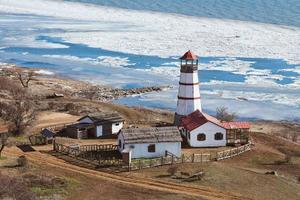 Beautiful white red lighthouse with farm utility houses in Merzhanovo, Rostov on Don Russian region photo