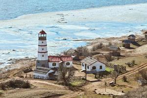 Beautiful white red lighthouse with farm utility houses in Merzhanovo, Rostov on Don Russian region photo